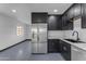 Updated kitchen features stainless appliances, dark cabinets, and stone countertops at 546 N 96Th Pl, Mesa, AZ 85207
