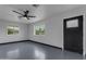 Airy living room featuring painted floor, neutral walls, and large windows for plenty of natural light at 546 N 96Th Pl, Mesa, AZ 85207