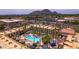 Aerial view of resort featuring a pool area, palm trees, and surrounding buildings with mountain views at 6333 N Scottsdale Rd # 5, Scottsdale, AZ 85250