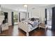Bright bedroom featuring a four-poster bed, hardwood floors, and natural light from large windows at 6333 N Scottsdale Rd # 5, Scottsdale, AZ 85250