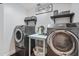 Functional laundry room equipped with modern washer and dryer, shelving, and ample workspace at 6333 N Scottsdale Rd # 5, Scottsdale, AZ 85250