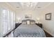 Calming main bedroom with elegant chandelier, white-painted wood ceiling, and shuttered windows at 6333 N Scottsdale Rd # 5, Scottsdale, AZ 85250