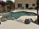 Backyard pool with rocks, desert landscaping, patio, and stucco home exterior at 6538 W Nez Perce St, Phoenix, AZ 85043