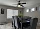 Dining room featuring a ceiling fan, gray tufted chairs, and a large window for plenty of natural light at 6538 W Nez Perce St, Phoenix, AZ 85043