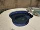 Backyard spa with blue mosaic tile, surrounded by concrete and stone at 6538 W Nez Perce St, Phoenix, AZ 85043