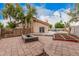 Backyard view with a firepit, garden beds, and block fence with a partial view of the pool at 845 N Oak Ct, Chandler, AZ 85226