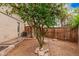 Backyard view of the fenced-in yard with mature trees and an air conditioning unit at 845 N Oak Ct, Chandler, AZ 85226