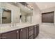 Well-lit bathroom with double sinks, a large mirror, and a separate tub at 845 N Oak Ct, Chandler, AZ 85226