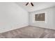 This bedroom features neutral carpeting, a ceiling fan, and a window for natural lighting at 845 N Oak Ct, Chandler, AZ 85226