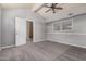 This bedroom features neutral carpeting, a ceiling fan, and a large window for natural lighting at 845 N Oak Ct, Chandler, AZ 85226