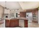 Open kitchen with granite countertops, stainless steel appliances, and a stone fireplace nearby at 845 N Oak Ct, Chandler, AZ 85226