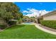 Beautiful backyard with a sparkling pool, covered patio, and lush landscaping at 8603 E Aster Dr, Scottsdale, AZ 85260