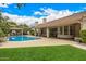 Backyard with a sparkling pool, a covered patio and well-maintained landscaping at 8603 E Aster Dr, Scottsdale, AZ 85260
