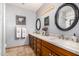 Spacious bathroom features double sinks with wooden cabinets and decorative framed mirrors at 8603 E Aster Dr, Scottsdale, AZ 85260