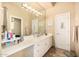Bathroom featuring a large mirror with vanity lighting, white cabinets and white countertops at 8603 E Aster Dr, Scottsdale, AZ 85260