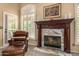 Elegant fireplace with detailed mantel, complemented by natural light from the window and patio access at 8603 E Aster Dr, Scottsdale, AZ 85260