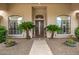 Elegant front entrance with a decorative glass door, flanked by lush greenery and decorative planters at 8603 E Aster Dr, Scottsdale, AZ 85260