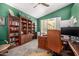 A stylish home office with built-in bookshelves and backyard views, creating a professional workspace at 8603 E Aster Dr, Scottsdale, AZ 85260