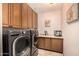 Functional laundry room equipped with modern washer and dryer, sink and ample cabinetry at 8603 E Aster Dr, Scottsdale, AZ 85260