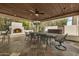 Spacious covered outdoor kitchen with a fireplace, dining area, and ceiling fan at 8603 E Aster Dr, Scottsdale, AZ 85260