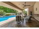 Inviting outdoor patio with comfortable seating area overlooking a pool and lush landscaping at 8603 E Aster Dr, Scottsdale, AZ 85260
