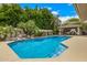 Inviting backyard pool with a rock waterfall feature and covered outdoor kitchen at 8603 E Aster Dr, Scottsdale, AZ 85260