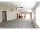 Open living area with carpet flooring, ceiling fans, and a partial view of the kitchen at 8832 W Manzanita Dr, Peoria, AZ 85345