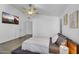 Bedroom with a ceiling fan, white walls, and a tv hanging on the wall at 10226 W Country Club Trl, Peoria, AZ 85383