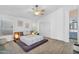 Light-filled bedroom featuring a ceiling fan, platform bed and en-suite bathroom at 10226 W Country Club Trl, Peoria, AZ 85383