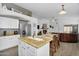 Open concept kitchen featuring stainless appliances, eat in island and views of the living area with fireplace at 10226 W Country Club Trl, Peoria, AZ 85383