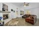 Cozy living room with fireplace, white walls and brick and leather furniture at 10226 W Country Club Trl, Peoria, AZ 85383
