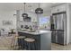 Modern kitchen boasts a large island, stainless steel appliances, white cabinetry, and pendant lighting at 10612 N 48Th Ave, Glendale, AZ 85304