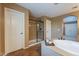 Bathroom features an oversized soaking tub, tile floors and a view of the glass-enclosed shower at 1086 S Nancy Ln, Gilbert, AZ 85296