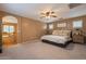 Comfortable bedroom boasts a ceiling fan, large bed, and windows with stylish shutters, leading to an ensuite bath at 1086 S Nancy Ln, Gilbert, AZ 85296
