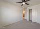 Bedroom with carpeted floor, ceiling fan, white walls, white closet doors, and standard doorway at 1086 S Nancy Ln, Gilbert, AZ 85296