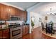 Stylish kitchen featuring stainless steel appliances, wood cabinetry, and an open layout to the dining area at 1086 S Nancy Ln, Gilbert, AZ 85296