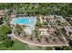 Aerial view of an inviting community pool area with lounge chairs, pergolas, and a splash pad, surrounded by lush greenery at 1086 S Nancy Ln, Gilbert, AZ 85296