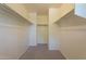 Spacious walk-in closet featuring ample storage with built-in shelving and neutral carpeting at 1086 S Nancy Ln, Gilbert, AZ 85296