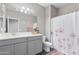 Well-lit bathroom featuring a shower, a white countertop and cabinets, and stylish décor elements at 12105 W Wier Ave, Avondale, AZ 85323