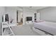 Bedroom with neutral carpet, TV, desk, and doorway to bathroom and kitchen at 12105 W Wier Ave, Avondale, AZ 85323