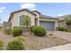 Beautiful home exterior with stone landscaping and a well-maintained two-car garage at 12105 W Wier Ave, Avondale, AZ 85323