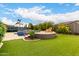 Backyard oasis with pool, trampoline, and lush greenery, perfect for Gathering fun and outdoor enjoyment at 12834 W Forest Pleasant Pl, Peoria, AZ 85383