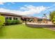 Lush backyard with artificial grass, patio, and pool offer a perfect space for outdoor entertaining and relaxation at 12834 W Forest Pleasant Pl, Peoria, AZ 85383