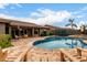 Backyard features a pool, patio, and lush lawn perfect for relaxation and entertaining at 12834 W Forest Pleasant Pl, Peoria, AZ 85383