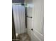 Cozy bathroom with white textured shower curtain, plank accent wall, and tiled floors at 12834 W Forest Pleasant Pl, Peoria, AZ 85383