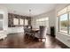 Elegant dining area featuring a brick accent wall, hardwood floors, and ample natural light at 12834 W Forest Pleasant Pl, Peoria, AZ 85383