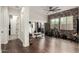 Spacious exercise room with wood flooring, exposed brick accent wall, fitness equipment, and plenty of natural light at 12834 W Forest Pleasant Pl, Peoria, AZ 85383