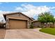 Charming single-story home with a well-manicured front yard, complemented by desert landscaping and a neutral color scheme at 12834 W Forest Pleasant Pl, Peoria, AZ 85383