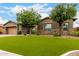 Charming single-story home with a well-manicured front yard, complemented by desert landscaping and a neutral color scheme at 12834 W Forest Pleasant Pl, Peoria, AZ 85383