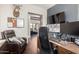 Home office with a leather recliner, multiple monitors, desk, and a view into the living room area at 12834 W Forest Pleasant Pl, Peoria, AZ 85383